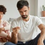 Contraception fail and unwanted pregnancy concept. Frustrated young family couple check pregnancy te