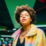 Portrait young curly hair fashionable and confident black woman indoor looking camera